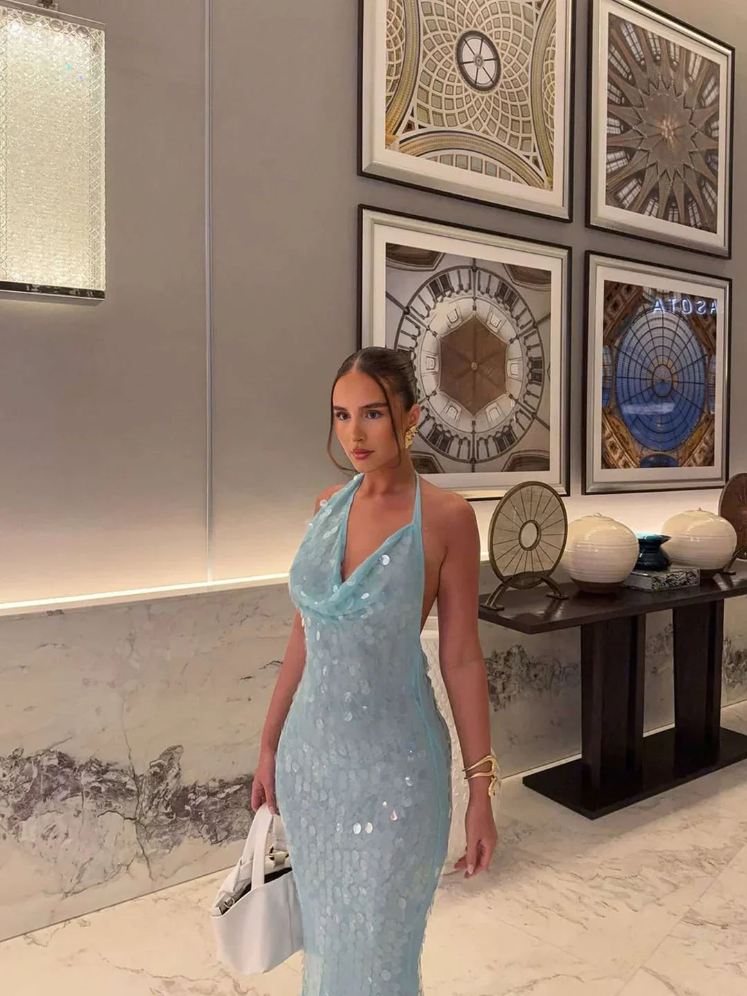 Robe longue en tissu pailleté bleu ciel, avec décolleté en V et manches légères, idéale pour les occasions spéciales.
