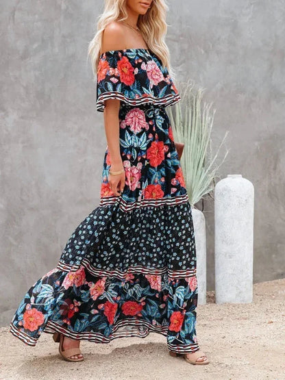 Robe longue à épaules dénudées, en tissu léger, avec motifs floraux colorés et design fluide, idéale pour l'été.