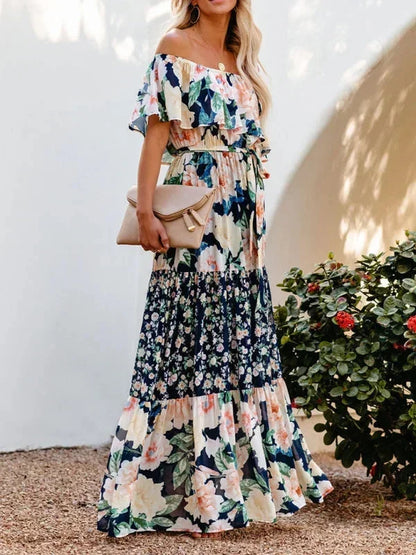 Robe longue femme à épaules dénudées, en coton léger, avec motifs floraux colorés sur fond pastel.