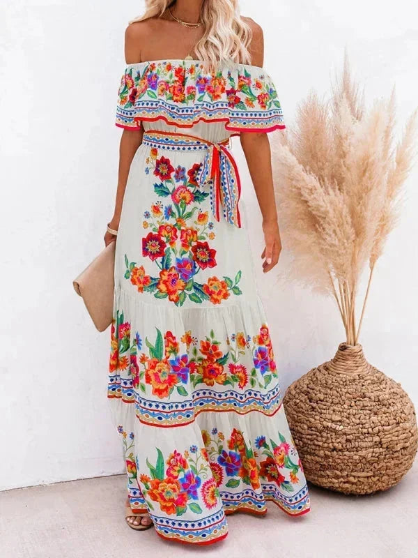 Robe longue femme avec épaules dénudées, en coton léger, ornée de motifs floraux colorés sur fond clair.