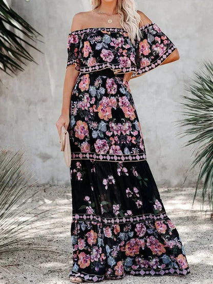 Robe longue noire à épaules dénudées, en tissu léger avec motifs floraux délicats, idéale pour les occasions estivales.