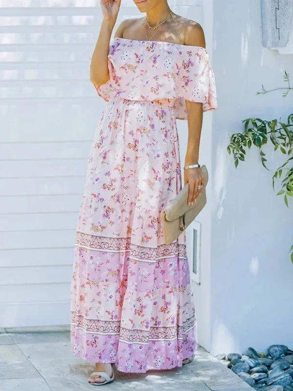 Robe longue rose à épaules dénudées, en tissu léger avec motifs floraux, idéale pour les journées ensoleillées.