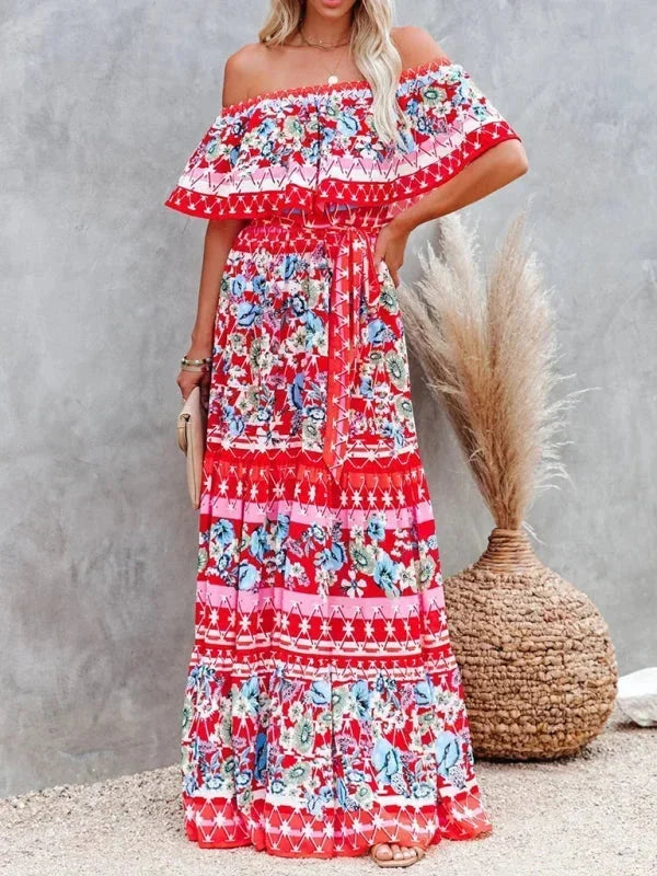 Robe longue femme rouge, à épaules dénudées, en tissu léger avec motifs floraux colorés sur tout le vêtement.