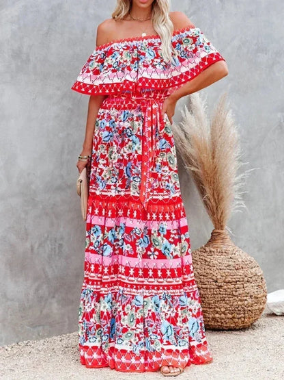 Robe longue femme rouge, à épaules dénudées, en tissu léger avec motifs floraux colorés sur tout le vêtement.