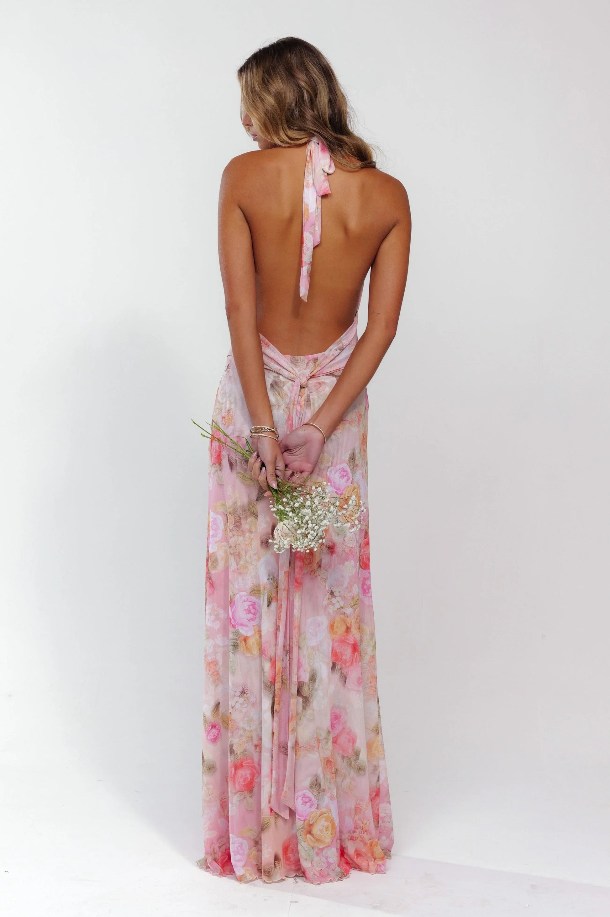 Robe longue femme rose fleurie en tissu léger, design dos nu avec motif floral, parfaite pour les journées ensoleillées.