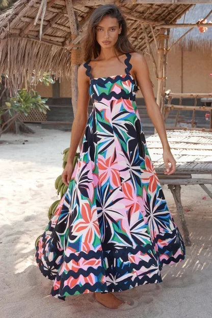 Robe longue sans manches en bleu foncé, avec un bord ondulé élégant et confectionnée dans un tissu léger et fluide.