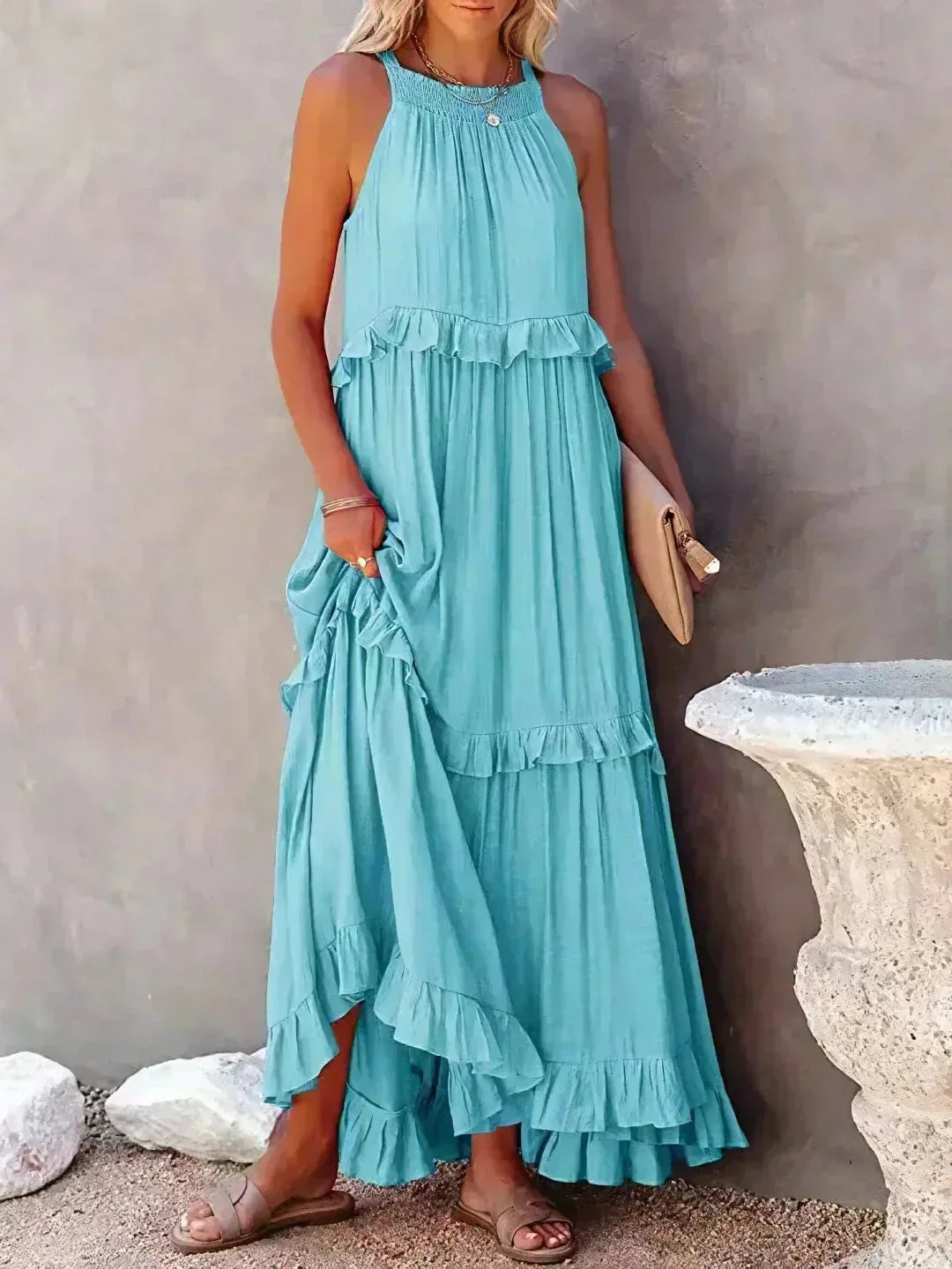 Robe longue bleu clair sans manches avec volants superposés en tissu léger pour une allure élégante et fluide.