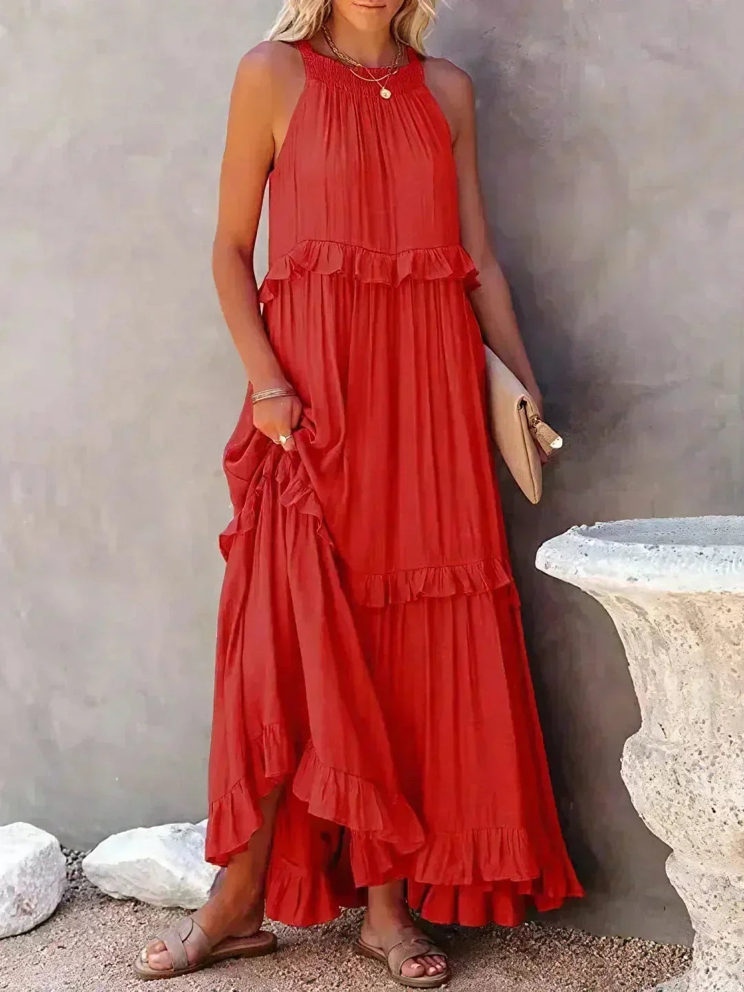Robe longue rouge sans manches avec volants superposés en tissu léger, idéale pour les journées ensoleillées.