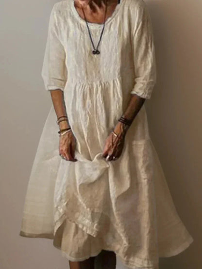 Robe longue beige femme à volants, col en V, manches 3/4, en tissu léger pour un confort optimal.