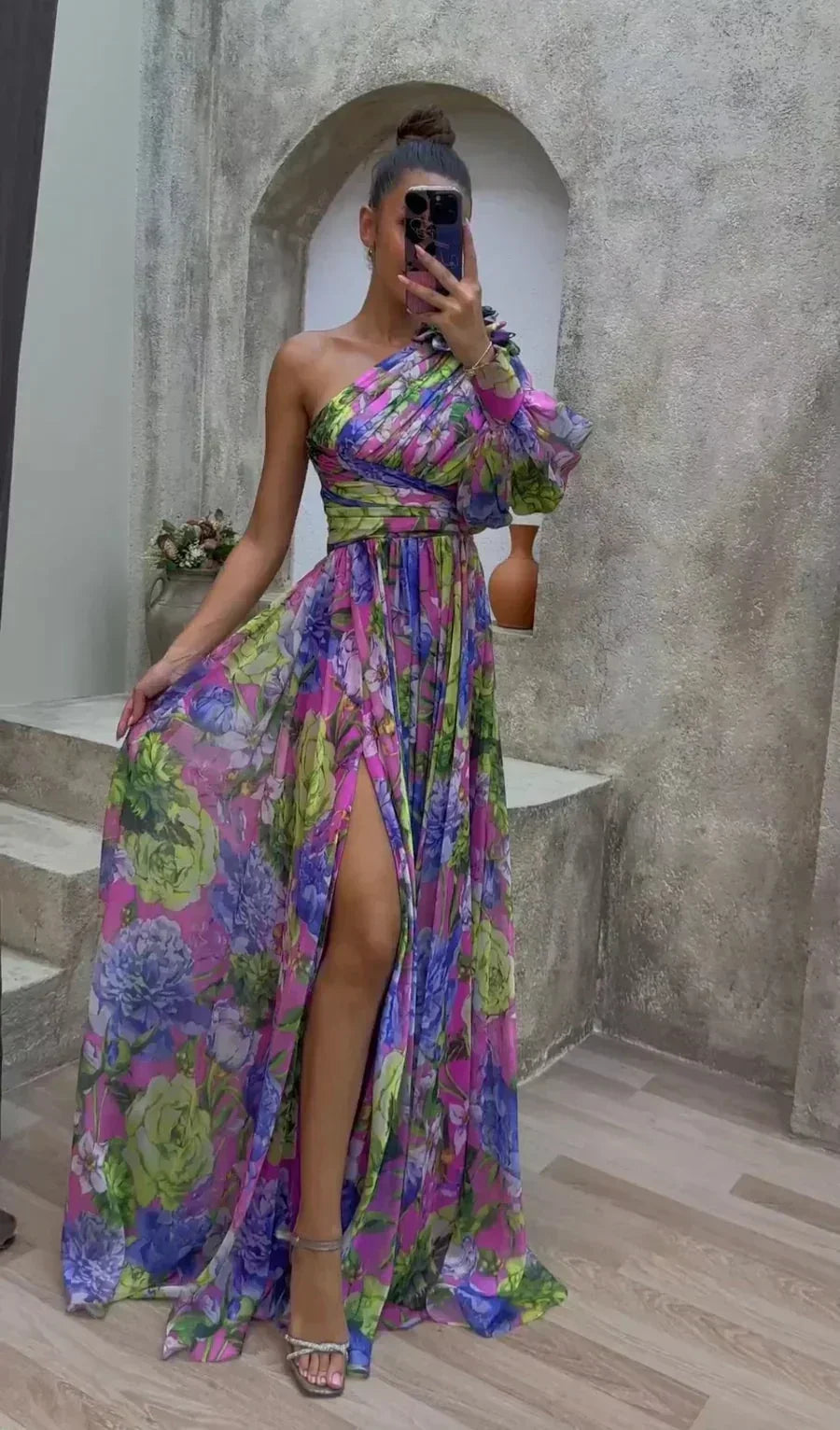 Robe longue fluide à une épaule fendue, imprimée de fleurs, idéale pour les soirées d'été. Matière légère et confortable.