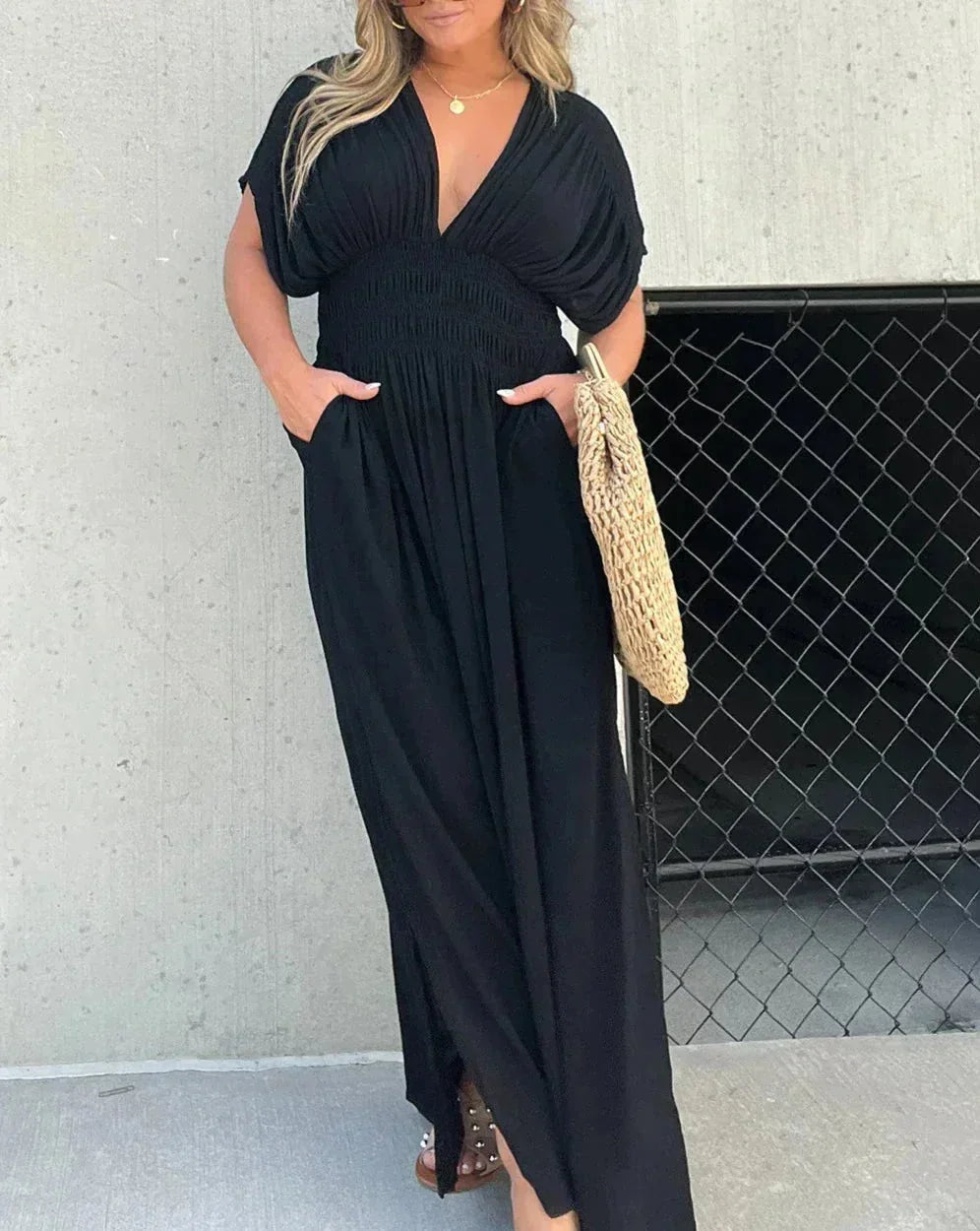 Robe longue fluide noire, col en V, manches courtes, en tissu léger, idéale pour un look décontracté et confortable.