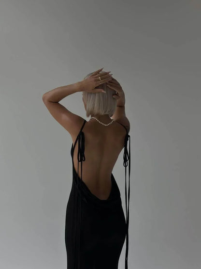 Robe longue élégante en tissu léger, dos nu avec liens ajustables pour un ajustement personnalisé et un style raffiné.