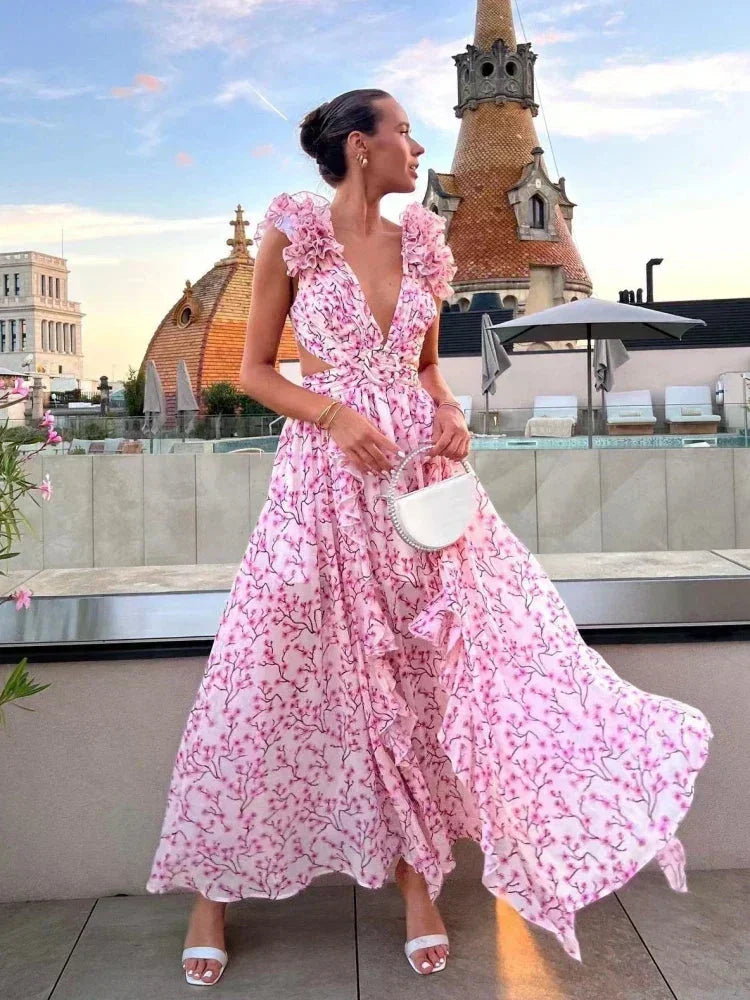 Robe longue rose en tissu léger, style portefeuille avec volants et détails floraux en V, idéale pour les soirées d'été.