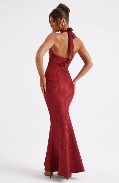 Robe longue rouge en satin avec col licou et nœud à la taille, parfaite pour les soirées élégantes.