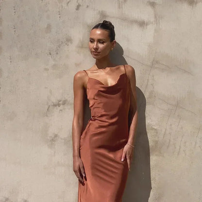 Robe longue sans manches en satin, col bénitier, disponible en plusieurs couleurs, avec une coupe fluide et élégante.