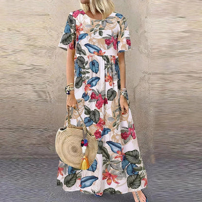 Robe longue blanche à volants, motif botanique, manches courtes en tissu léger pour une allure estivale et fraîche.