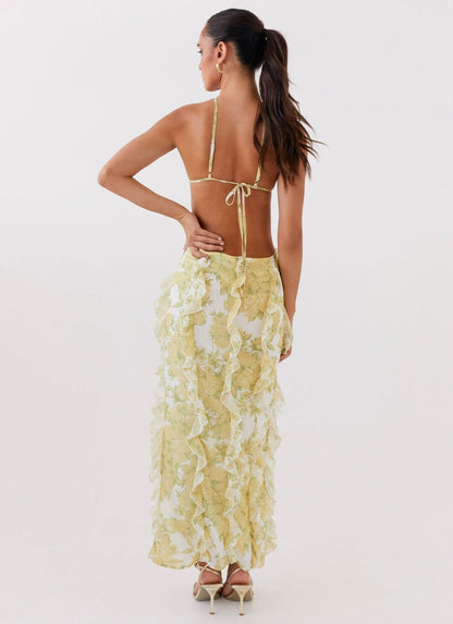 Robe longue à volants en coton, avec un motif floral jaune éclatant, idéale pour les journées ensoleillées.