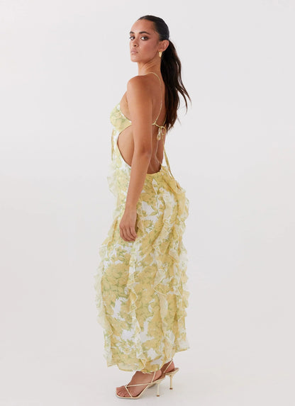 Robe longue à volants en tissu léger, avec un motif floral jaune vibrant et des manches courtes pour une allure estivale.