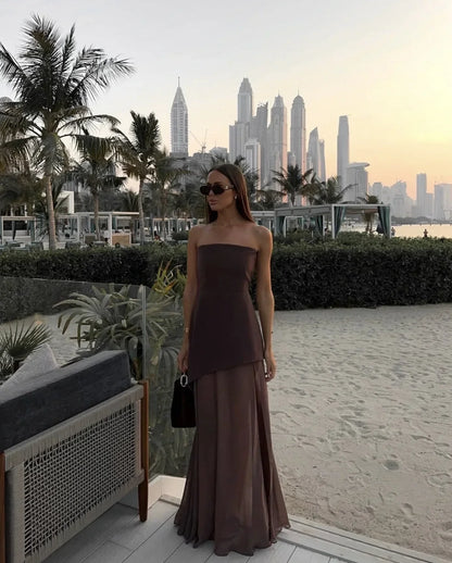 Robe longue asymétrique sans manches en tissu fluide, col bustier, détail à étage pour un look élégant en soirée.