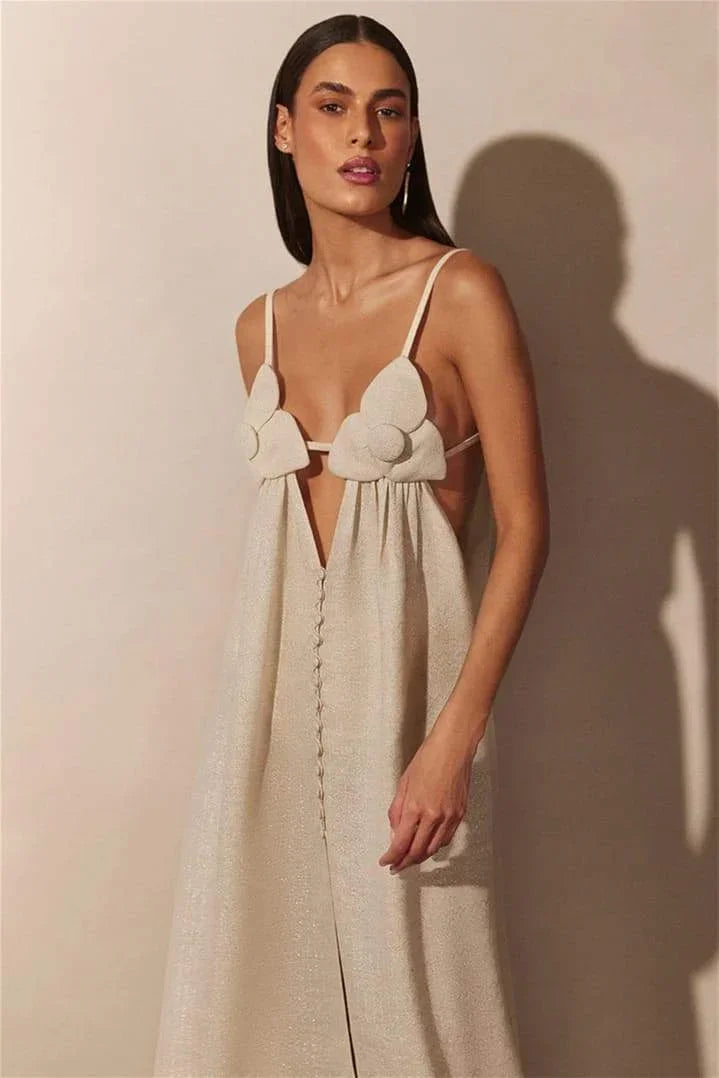 Robe longue beige en tissu léger, ornée de détails floraux et d'une élégante fente, idéale pour une soirée.