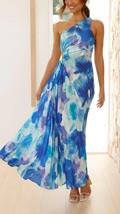 Robe longue bleue avec motifs floraux, plissée, asymétrique à une épaule, faite de tissu léger, idéale pour l'été.