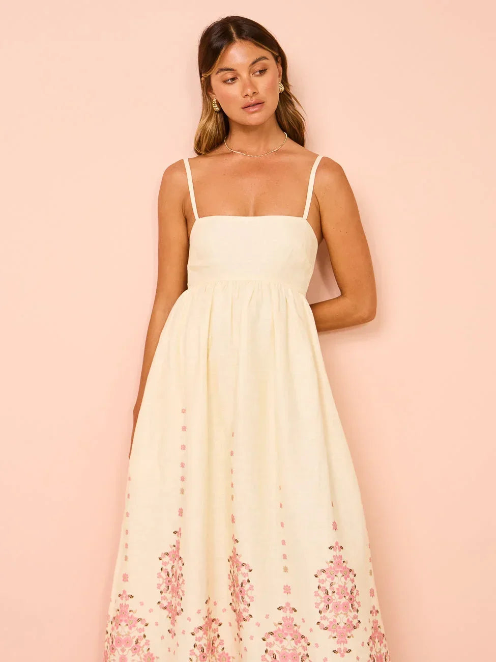 Robe longue crème en coton, broderie florale délicate et bretelles fines, parfaite pour les journées d'été.