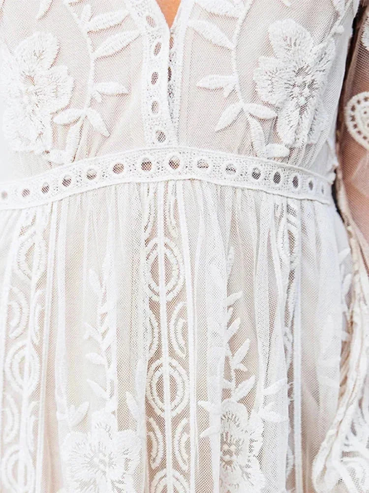 Robe longue en dentelle transparente, manches longues, col en V, idéale pour une soirée élégante. Détails raffinés et fluidité.