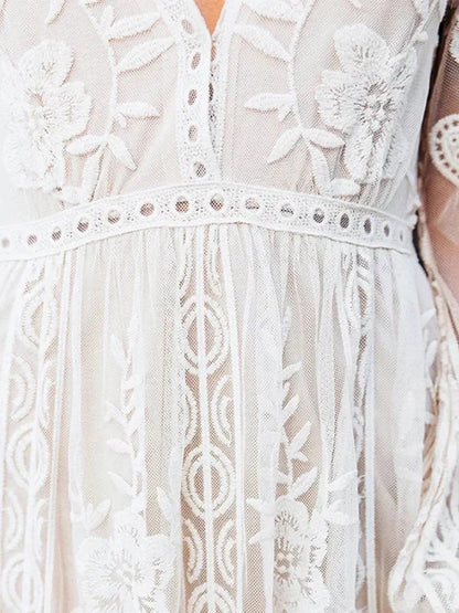 Robe longue en dentelle transparente, manches longues, col en V, idéale pour une soirée élégante. Détails raffinés et fluidité.