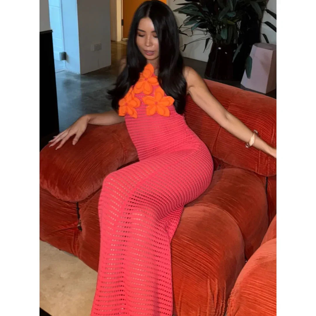 Robe maxi en crochet rose ornée de fleurs oranges, légère et ajourée, idéale pour les journées ensoleillées.