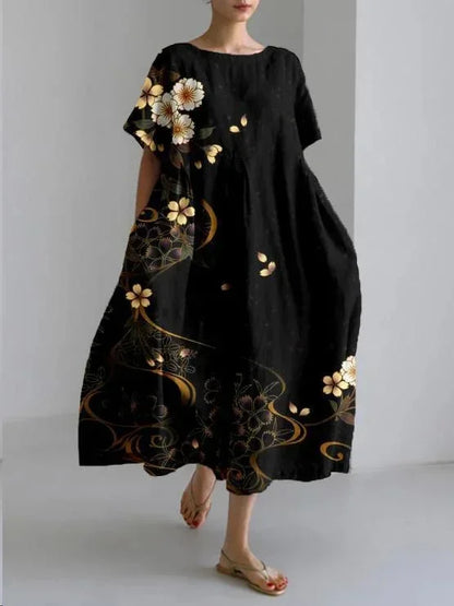 Robe maxi noire à fleurs dorées, ample avec manches courtes et poches pratiques, en tissu léger et fluide.