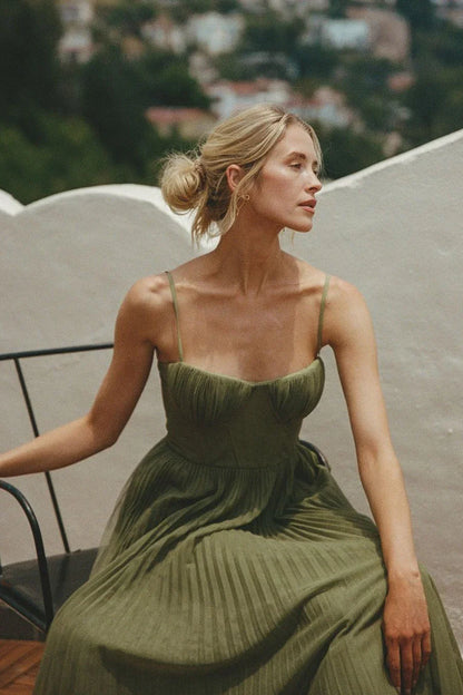 Robe maxi femme verte plissée en tissu léger, décorée de plis élégants et avec des bretelles fines pour un look décontracté.
