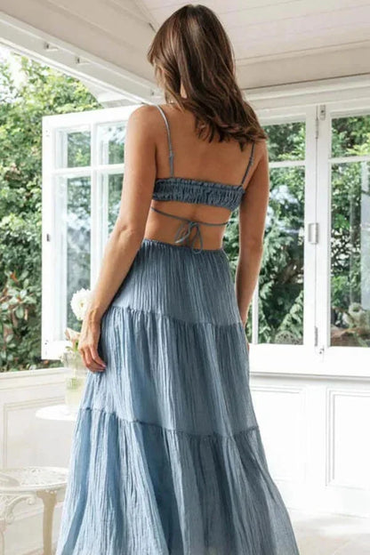 Robe longue féminine avec bretelles fines, dos nu et tissu léger, idéale pour l'été avec un design volanté.