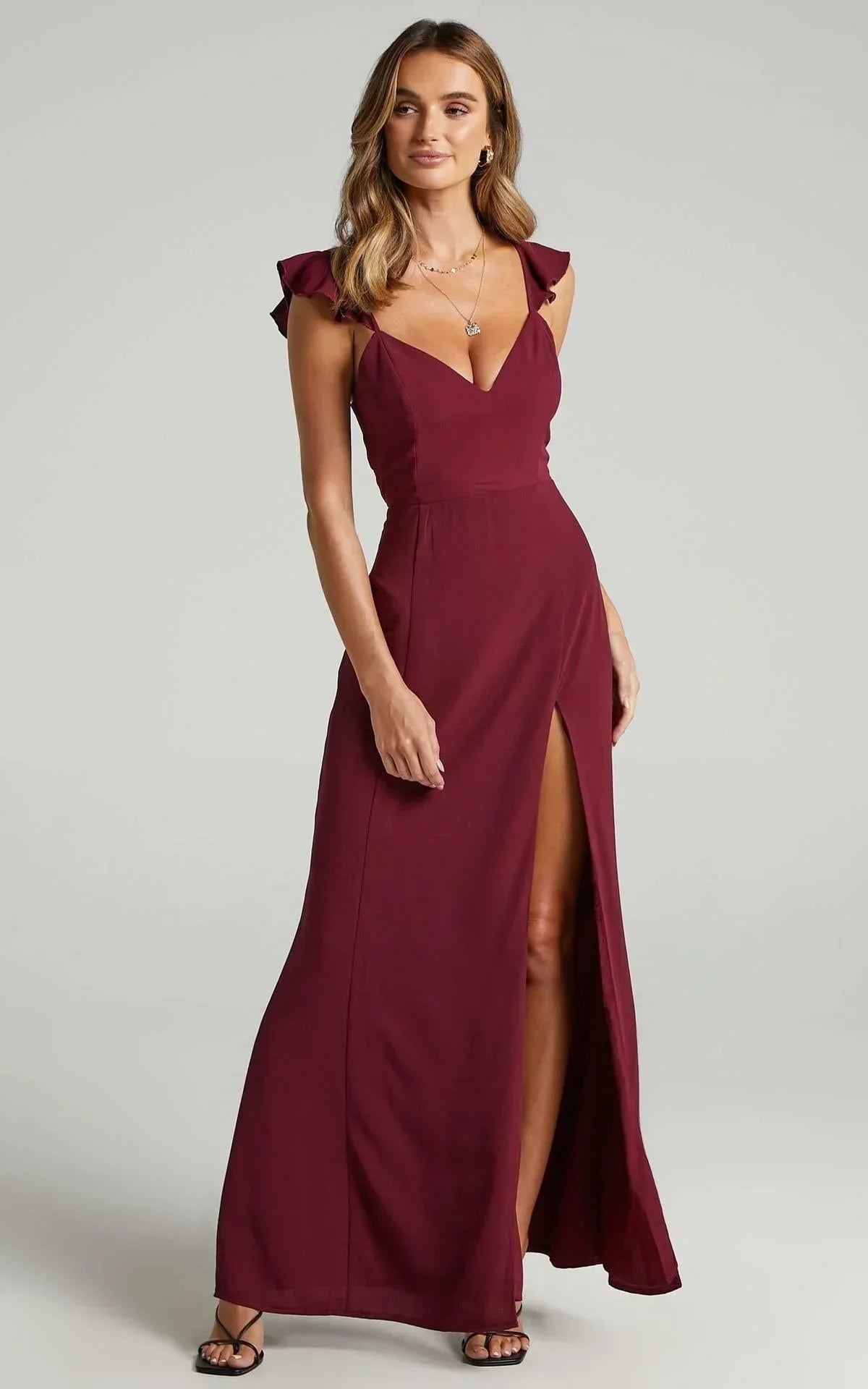 Robe longue fendue avec manches à détails, en tissu léger, parfaite pour les soirées. Idéale pour un look élégant.