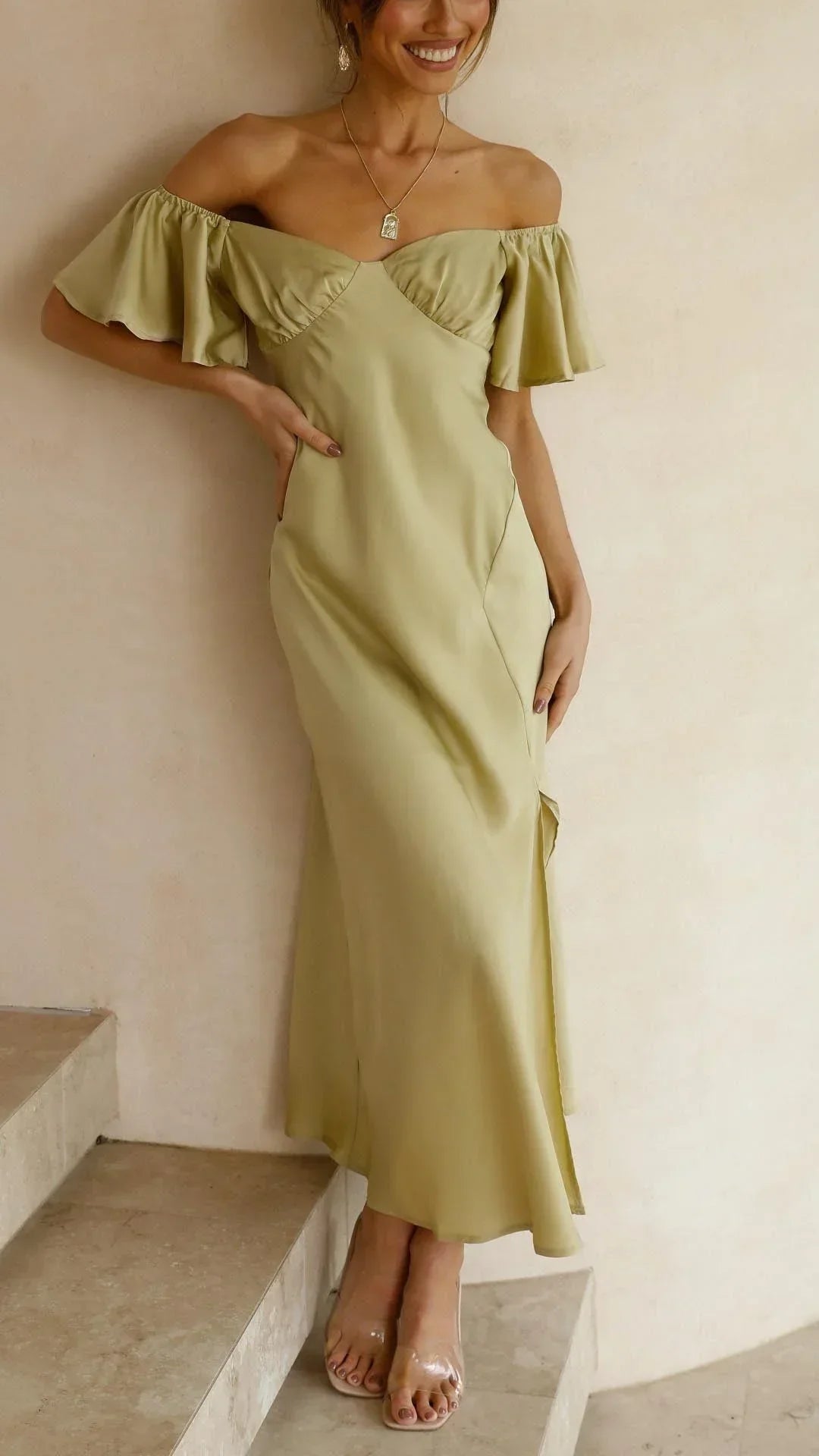 Robe longue fluide, fendue avec épaules dénudées, parfaite pour les soirées d'été. Tissu léger et élégant, silhouette féminine.