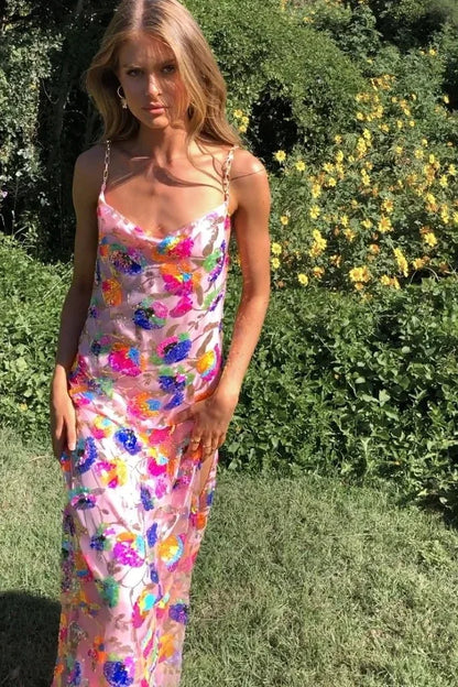 Robe longue fleurie en tissu léger, avec fente sur la jambe, col drapé et bretelles fines pour une silhouette fluide.