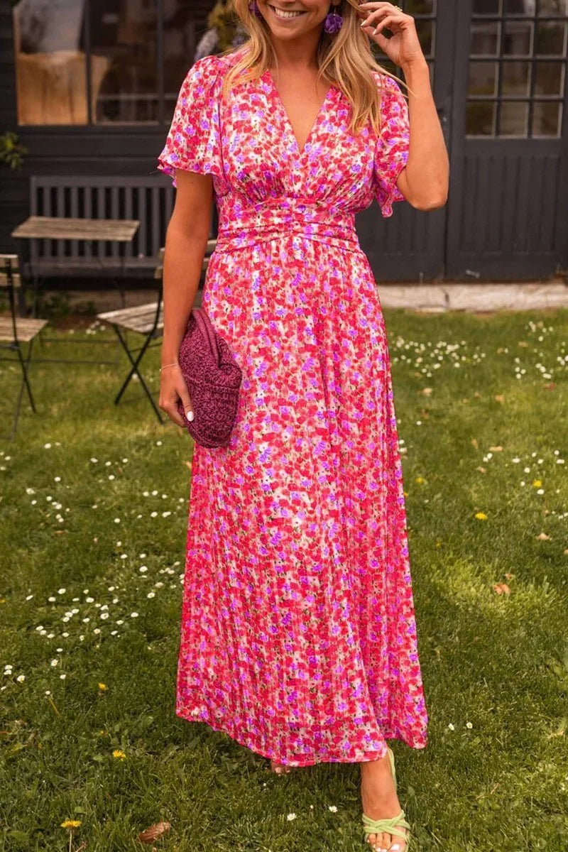 Robe longue fleurie en tissu fluide avec manches courtes et col en V, idéale pour l'été.
