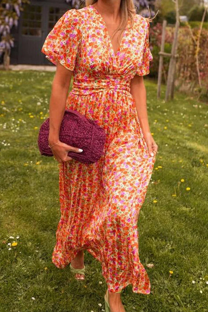 Robe longue fleurie avec manches courtes, col en V, en tissu fluide, idéale pour l'été et les journées ensoleillées.
