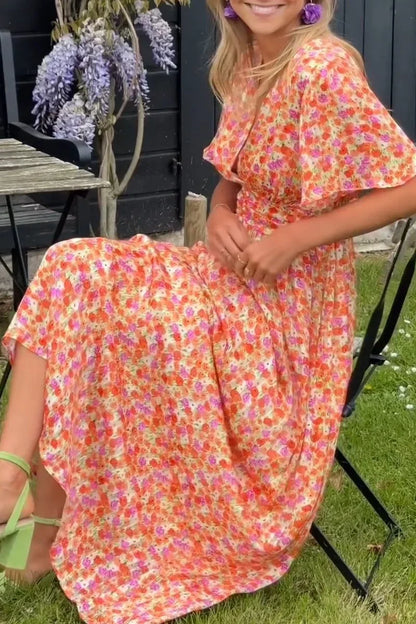 Robe longue fleurie à manches courtes, col en V, en tissu fluide parfait pour l'été, avec motifs floraux colorés.