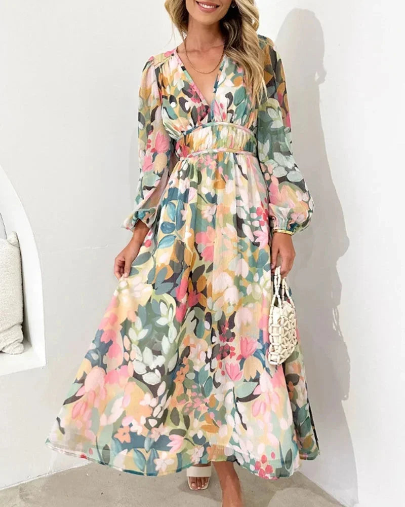Robe longue fleurie en tissu fluide, manches longues, col en V, taille cintrée, idéale pour un mariage au printemps.