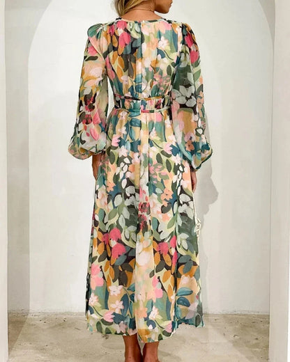 Robe longue fleurie en tissu fluide, col en V et manches longues, avec taille cintrée, parfaite pour un mariage au printemps.