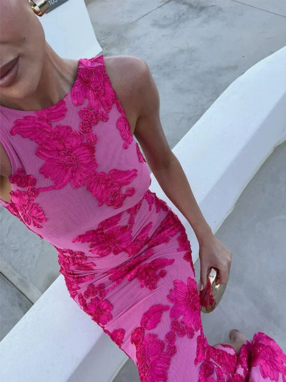 Robe longue fleurie rose sans manches, en tissu léger, offrant un style délicat et fluide pour les soirées d'été.