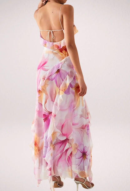 Robe longue fleurie rose sans manches avec volants, en tissu léger, idéale pour les journées estivales ensoleillées.