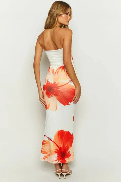 Robe longue fleurie sans bretelles blanche et orange, en tissu léger idéal pour l'été, avec un motif floral coloré.