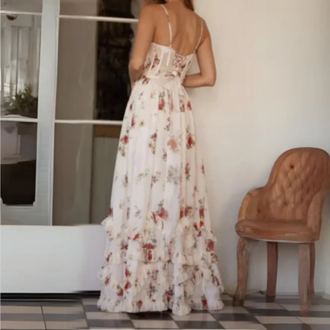 Robe longue fleurie sans manches avec fente, décolleté et tissu léger, idéale pour l'été. Design élégant et fluide.