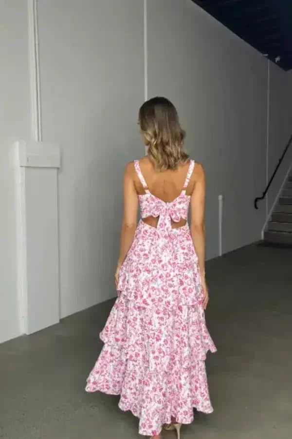 Robe longue florale en tissu léger, avec volants, bretelles ajustables et nœud au dos, idéale pour les occasions estivales.