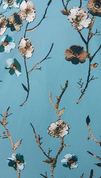 Robe longue bleu clair avec imprimé floral, manches mi-longues, col en V. Idéale pour l'été, en tissu léger et fluide.