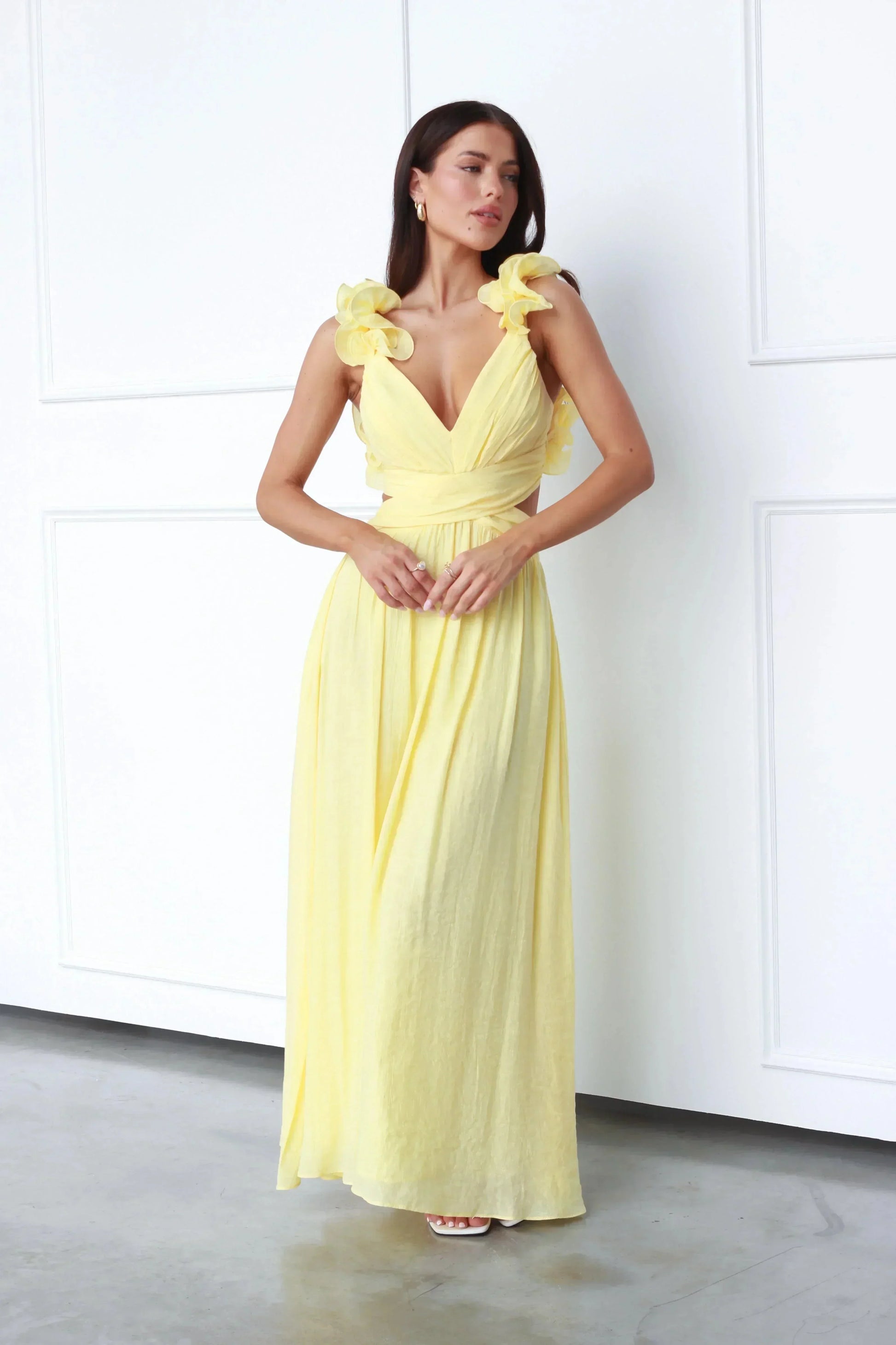 Robe longue jaune sans manches, col en V, tissu fluide et léger avec accents floraux, idéale pour l'été.