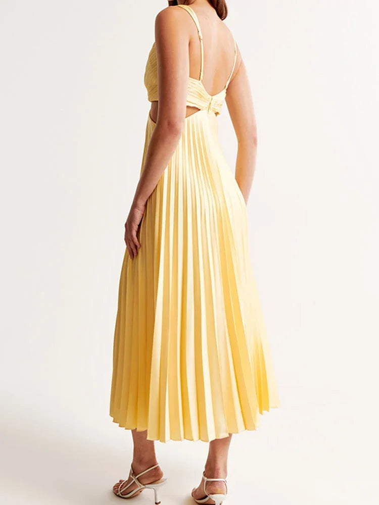 Robe longue jaune plissée avec col plongeant et découpes, parfaite pour une soirée estivale en matériau léger et fluide.