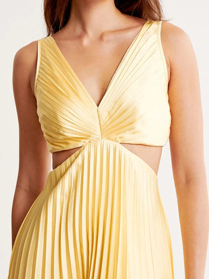 Robe longue jaune plissée avec col plongeant, découpes élégantes et tissu léger, parfaite pour une soirée estivale.