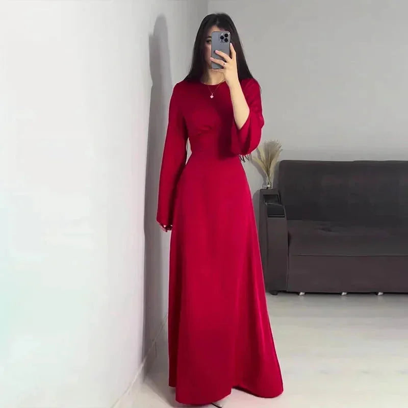 Robe longue longue en satin, avec manches évasées, disponible en plusieurs couleurs. Design fluide et élégant.